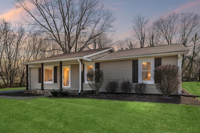 ranch-style house with a front yard and covered porch