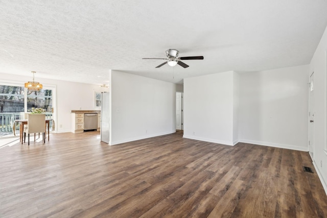 unfurnished living room featuring dark wood-style floors, visible vents, a textured ceiling, baseboards, and ceiling fan with notable chandelier