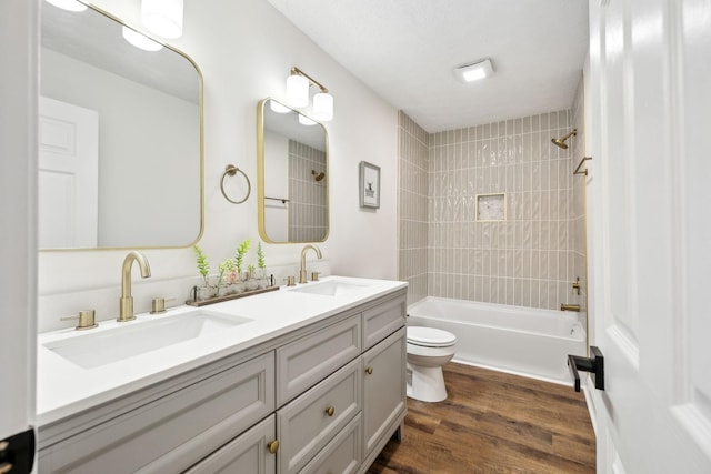 full bathroom with toilet, wood finished floors, a sink, and bathing tub / shower combination