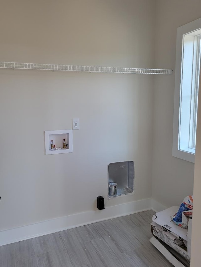 clothes washing area with washer hookup, light hardwood / wood-style floors, and plenty of natural light