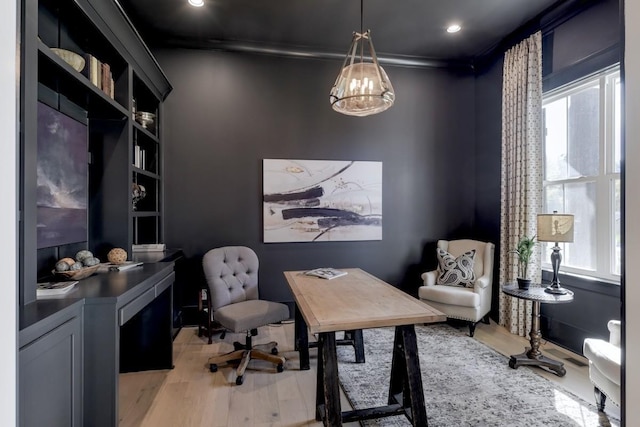 home office with crown molding and light hardwood / wood-style floors