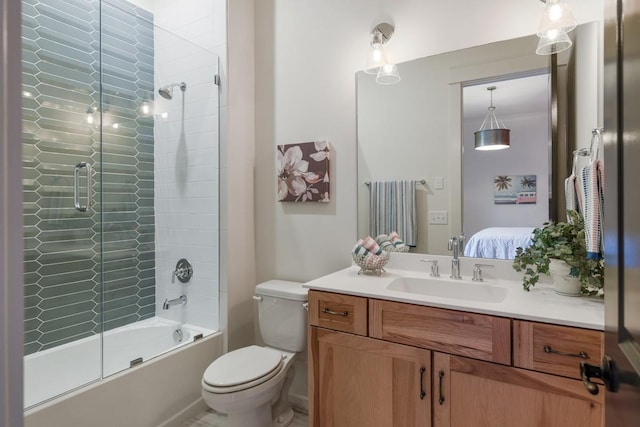 full bathroom with vanity, bath / shower combo with glass door, and toilet