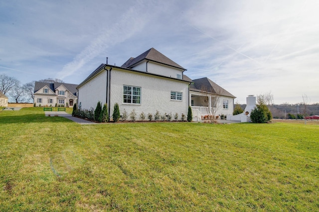 rear view of property featuring a lawn