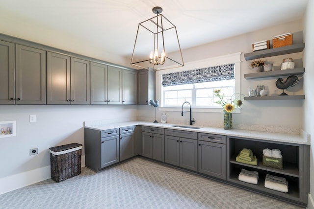 interior space featuring sink, gray cabinetry, and decorative light fixtures