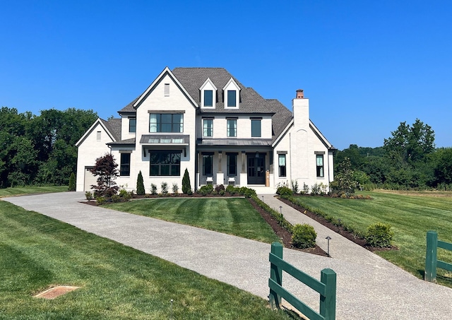 modern farmhouse featuring a porch, a front lawn, and fence