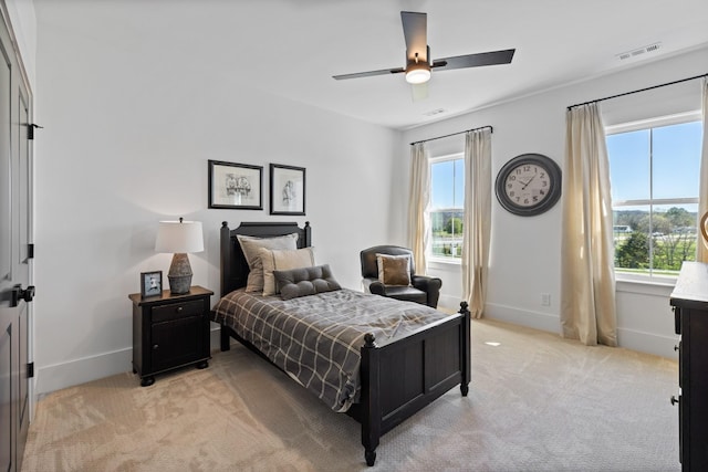 carpeted bedroom with multiple windows and ceiling fan