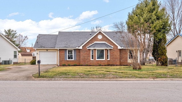 view of front of house with a garage, a front yard, and central AC unit