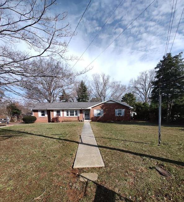 single story home featuring a front lawn