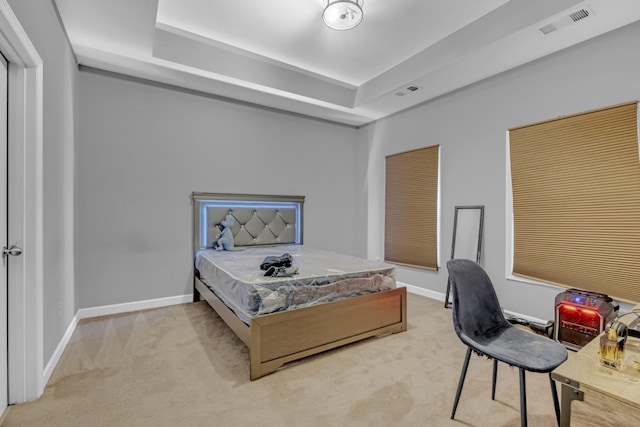 carpeted bedroom with a tray ceiling