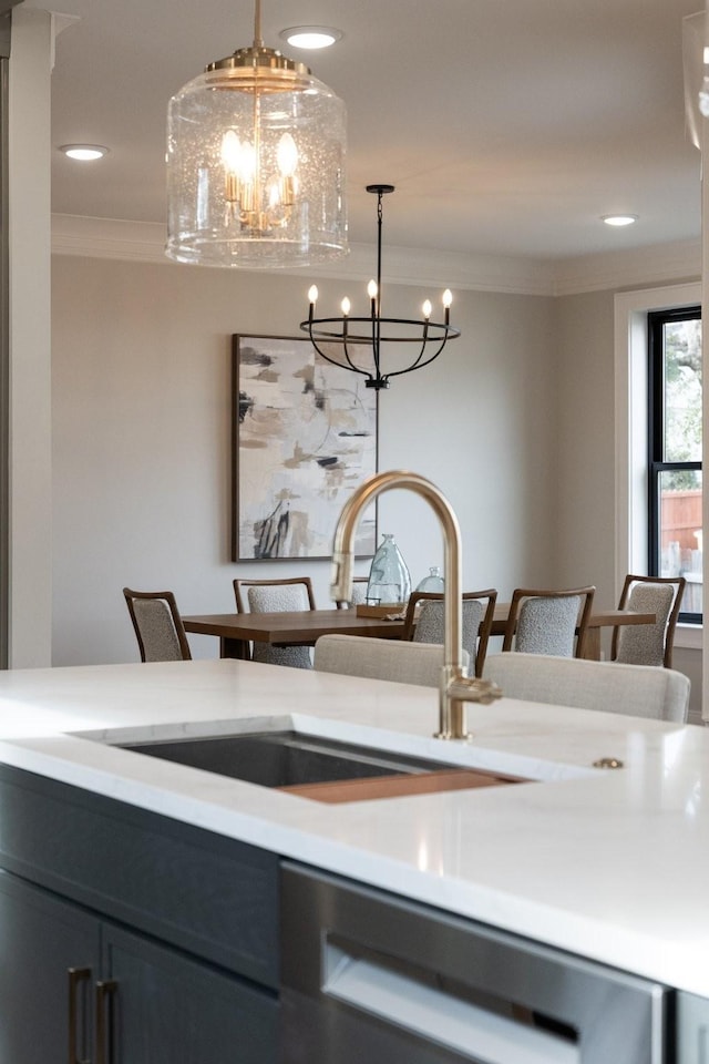 details with a notable chandelier, light countertops, stainless steel dishwasher, ornamental molding, and a sink