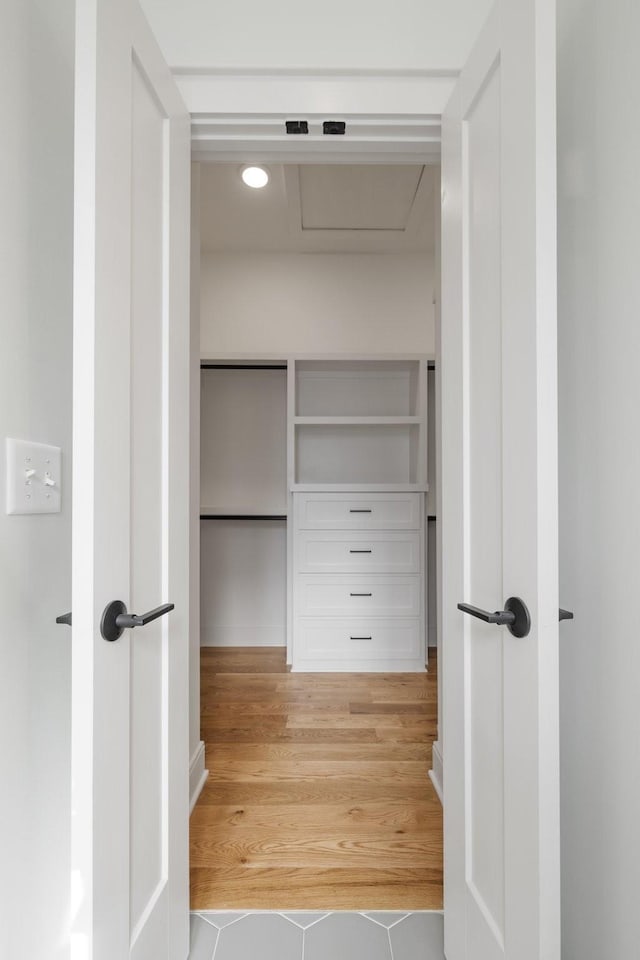 walk in closet with wood finished floors