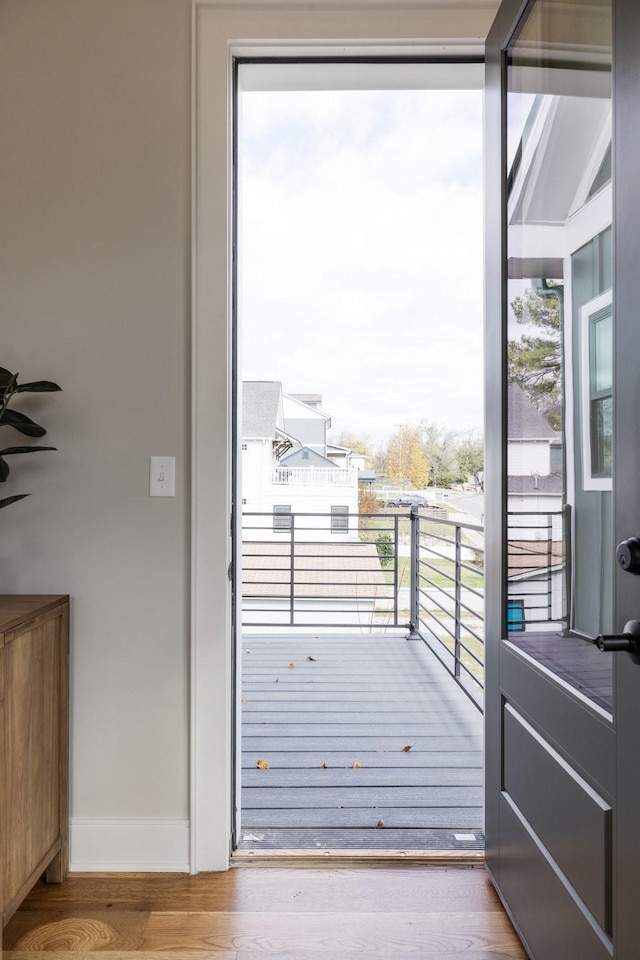 doorway featuring baseboards and wood finished floors