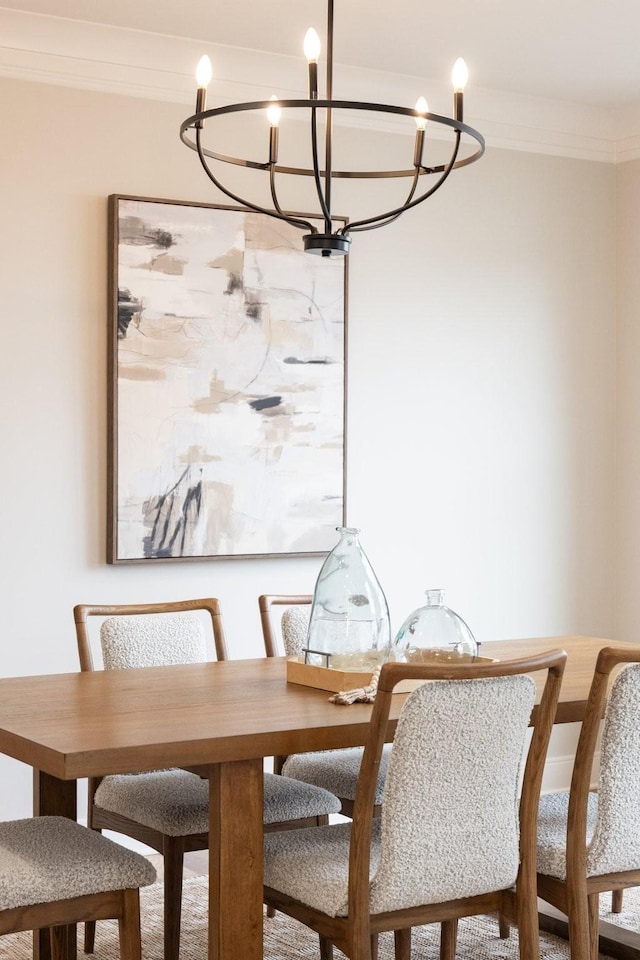 dining area with ornamental molding and an inviting chandelier