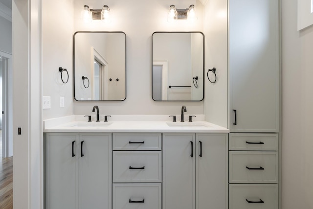 full bath with double vanity, wood finished floors, and a sink