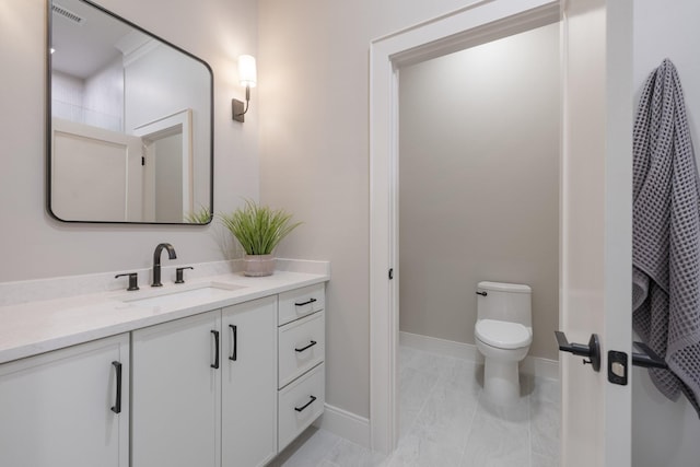 bathroom with visible vents, baseboards, vanity, and toilet