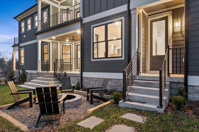 exterior space featuring a balcony, a fire pit, and board and batten siding