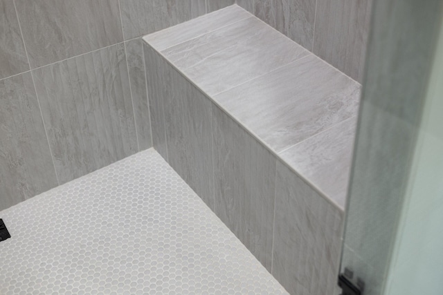 interior details featuring a tile shower