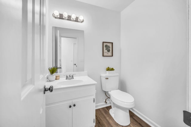 bathroom with vanity, toilet, and wood-type flooring