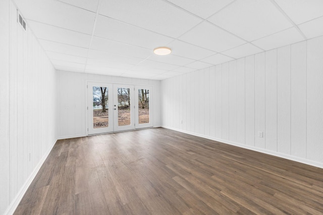 spare room featuring a drop ceiling, dark hardwood / wood-style floors, and french doors