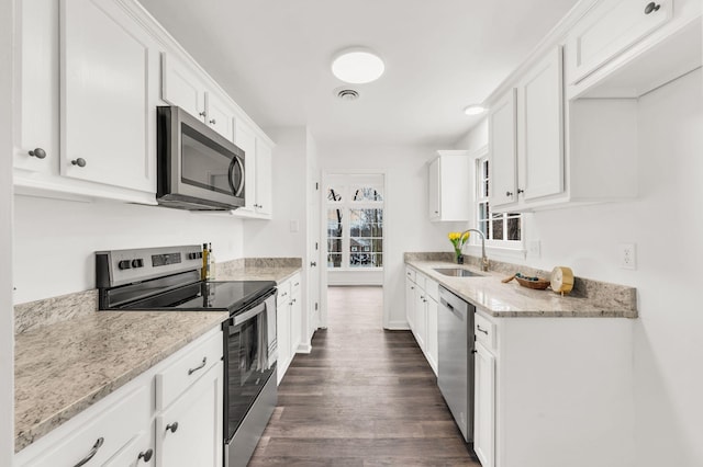 kitchen with white cabinetry, sink, stainless steel appliances, and light stone countertops