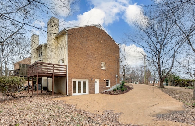 rear view of house with a wooden deck and french doors