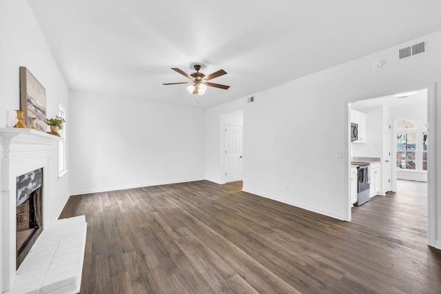 unfurnished living room with dark hardwood / wood-style floors, ceiling fan, and a fireplace