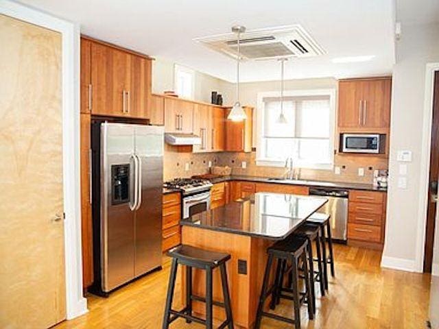 kitchen with sink, hanging light fixtures, a kitchen breakfast bar, a kitchen island, and stainless steel appliances