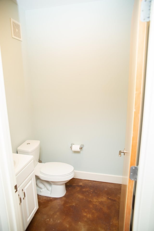 bathroom with vanity, concrete flooring, and toilet