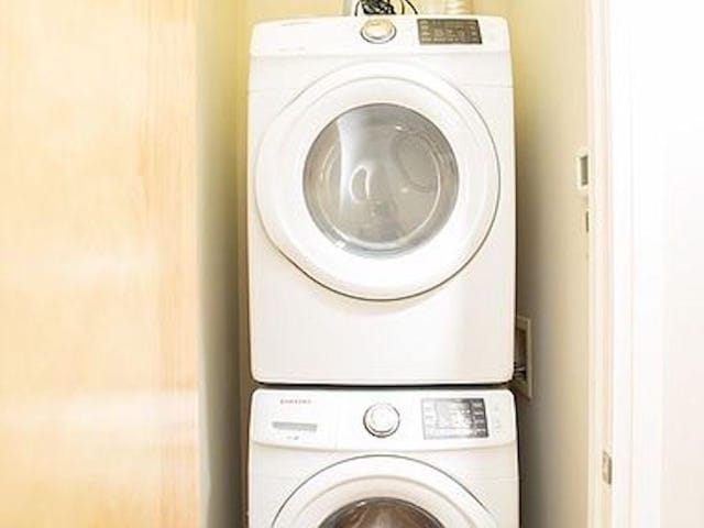 clothes washing area featuring stacked washer and dryer