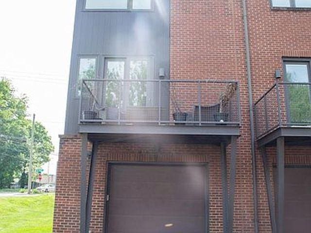 rear view of house featuring a garage and a balcony