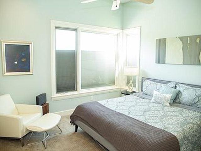 carpeted bedroom with ceiling fan and lofted ceiling