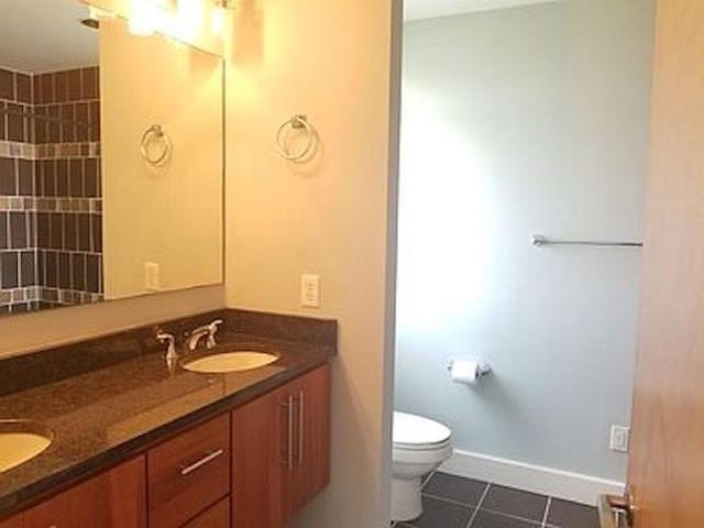 bathroom with tile patterned flooring, vanity, and toilet