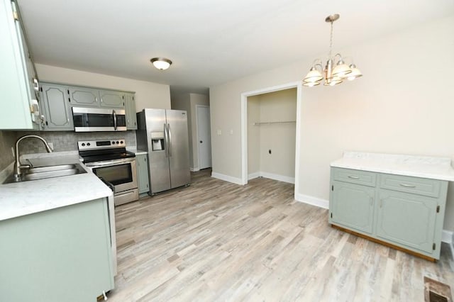 1765 Copperfield Ct, Clarksville, TN 37042 - kitchen with backsplash, light countertops, light wood-type flooring, appliances with stainless steel finishes, and a sink