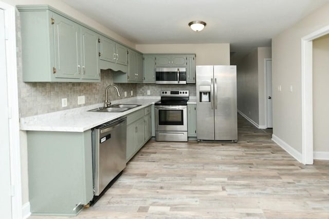 1765 Copperfield Ct, Clarksville, TN 37042 - kitchen featuring a sink, light countertops, light wood-style floors, appliances with stainless steel finishes, and backsplash