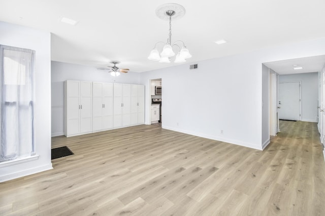 unfurnished living room featuring ceiling fan with notable chandelier and light wood-type flooring