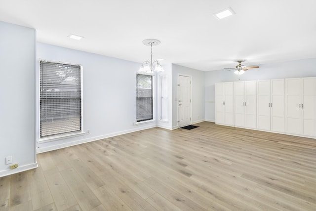 interior space with ceiling fan with notable chandelier and light hardwood / wood-style floors