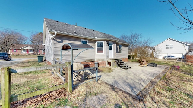 rear view of property featuring a patio and a fire pit