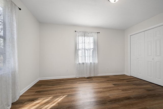 unfurnished bedroom featuring dark hardwood / wood-style flooring and a closet