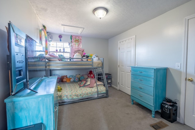 bedroom with light colored carpet and a textured ceiling