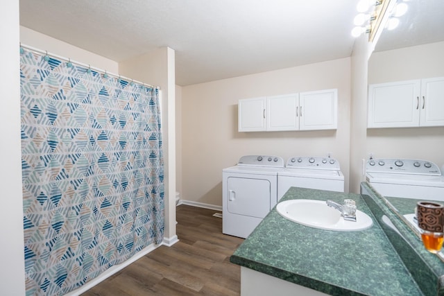 laundry area featuring dark hardwood / wood-style floors, sink, and washer and clothes dryer