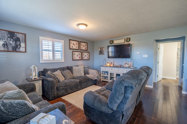 living room with dark wood-type flooring and a textured ceiling