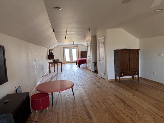 bonus room featuring lofted ceiling, light hardwood / wood-style flooring, and french doors