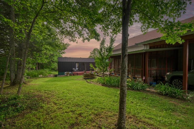view of green lawn with a sunroom