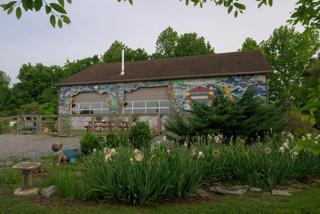 back of property featuring fence and a garage