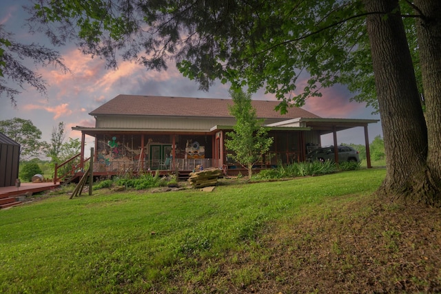 back of property featuring a lawn and a shingled roof