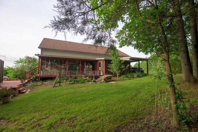 rear view of house featuring a lawn and a shingled roof
