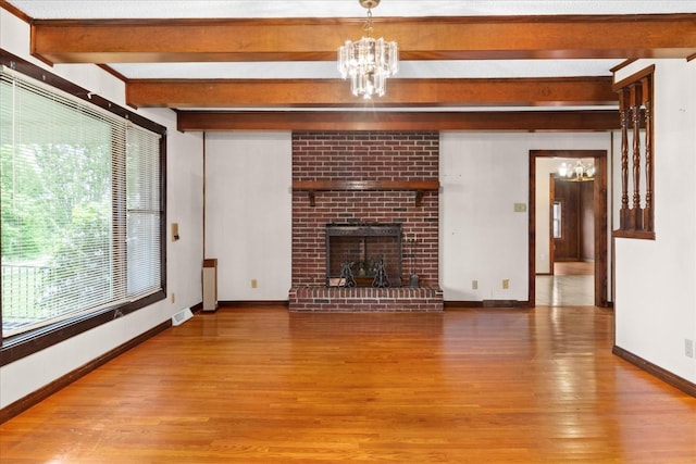 1144 Miller Rd, Lewisburg, TN 37091 - unfurnished living room featuring a chandelier, beamed ceiling, wood finished floors, a fireplace, and baseboards