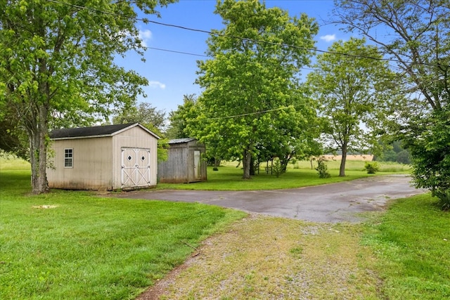 1144 Miller Rd, Lewisburg, TN 37091 - view of green lawn with a storage unit, an outdoor structure, and driveway