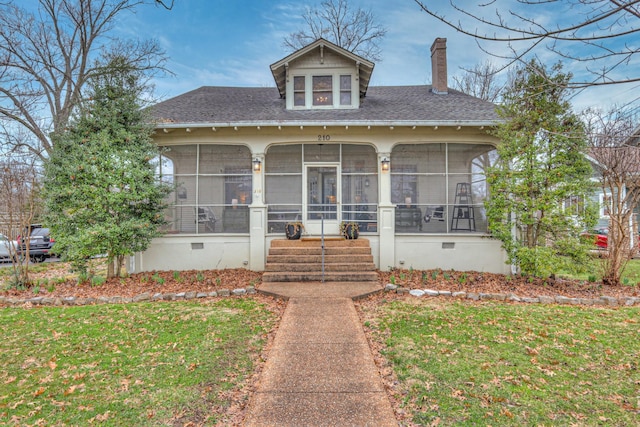 view of front facade with a sunroom and a front yard