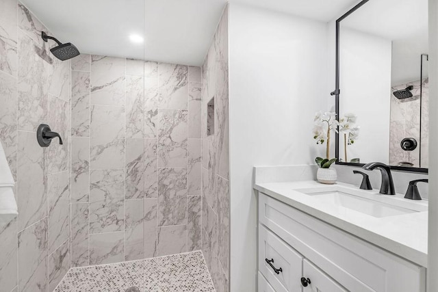 bathroom featuring tiled shower and vanity